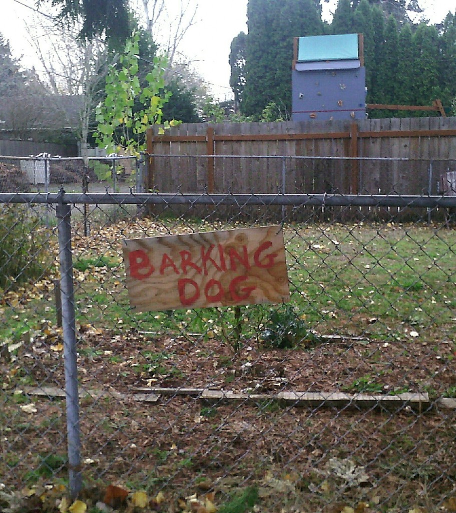 sign on fence: BARKING DOG