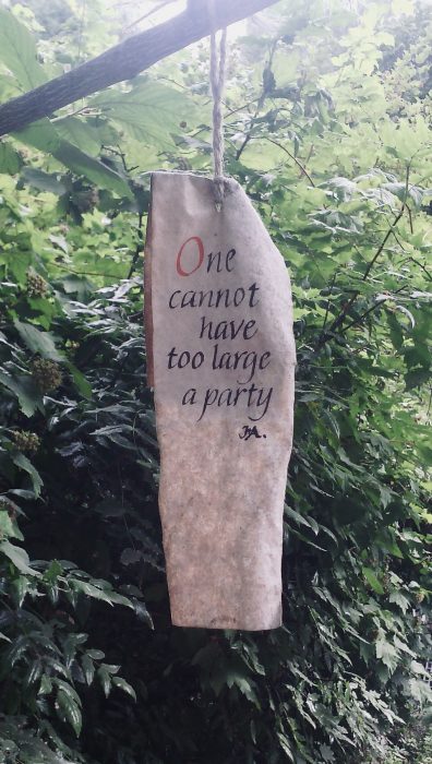 weathergram hanging in shrubbery: "One cannot have too large a party"