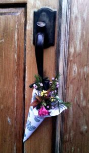 wooden door at Taborspace with a conical May basket tied to the latch