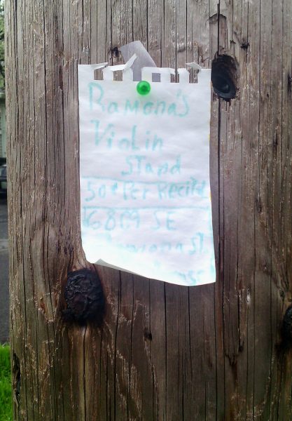 Handwritten sign pinned to telephone pole
